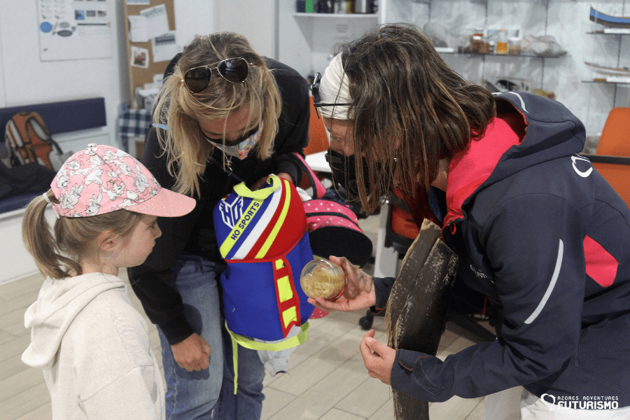 Guardians of the Azores | A member of our team showing some of our scientific material to a young girl after a cleanup event.